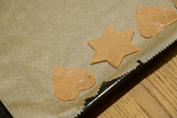 Homemade Gingerbread Cookies cut into Christmas star and heart shapes ready for baking