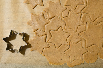 Homemade Gingerbread Cookies cutting forms and gingerbread dough on Baking paper ready for baking