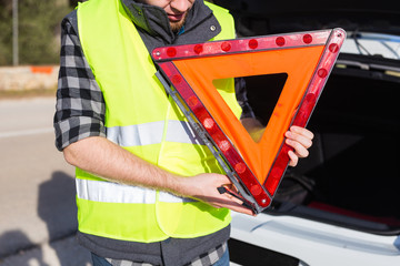 A man holding a triangular sign of an accident