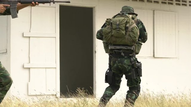 Soldier holding gun weapon and waring armor uniform. The military is responsible for maintaining the territory.