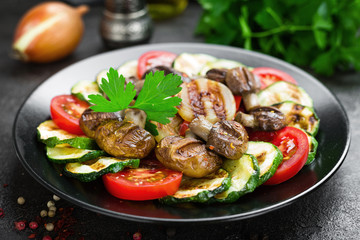 Salad with fresh and grilled vegetables and mushrooms. Vegetable salad with grilled champignons. Vegetable salad on plate