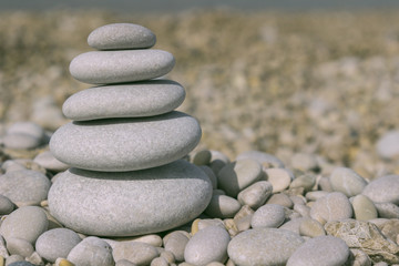 Fototapeta na wymiar Grey pebbles: stone cairn tower, poise stones, zen sculpture.