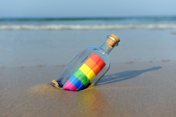 Mensaje del orgullo gay en una botella a la orilla del mar