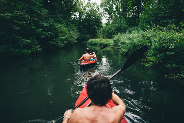 Zwei Freunde befahren mit ihren Kajaks einen Fluss