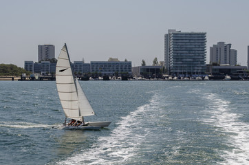 Naklejka premium embarcacion de recreo navegando frente al puerto deportivo de la Troia Portugal