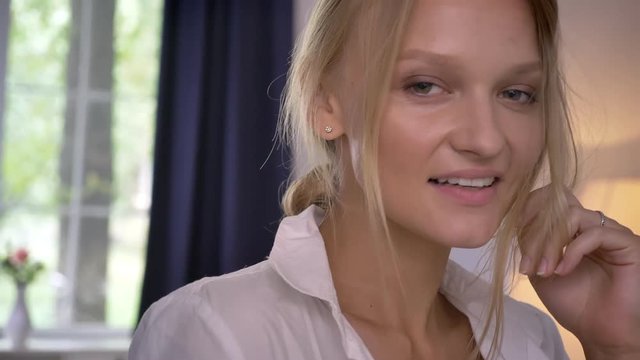 Young sexy blonda girl in lingerie is standing in room, smiling, flirt concept