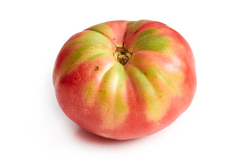 Imperfect heirloom organic tomato isolated on white background