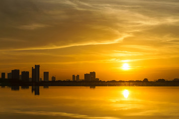 Fototapeta premium Beautiful golden sunset over the infinity pool and skyline