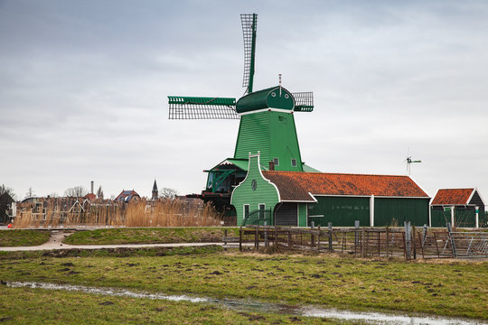 Old wooden Windmill near green barns