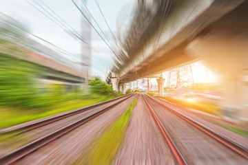 Fototapeta na wymiar View of railway tracks motion blur and highway bridges at sunset.