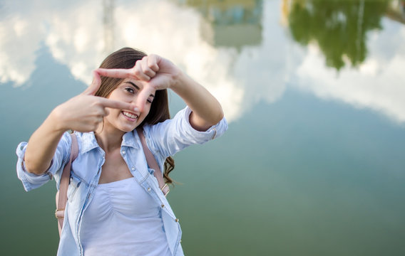 Smiling Beautiful Girl Making Frame With Her Fingers, Pretending To Take Photo