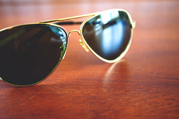 dark green and golden fashion sunglasses on the table, retro toned