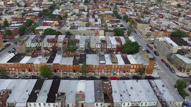 Flying over Baltimore City Row homes looking at the rooftop decks and streets below.