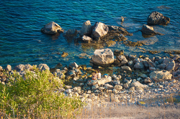 one couple of two young people sitting on a boulder