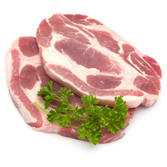Raw pork neck chop meat with parsley herb leaves garnish isolated on white background cutout