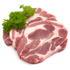 Raw pork neck chop meat with parsley herb leaves garnish isolated on white background cutout