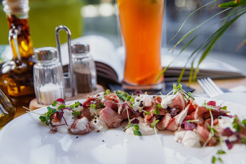 Beef carpaccio on white plate.