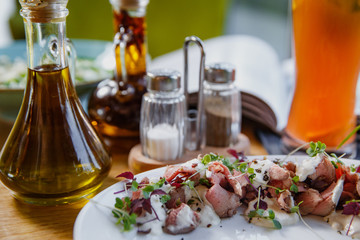 Beef carpaccio on white plate.