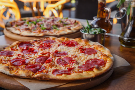 Pizza with pepperoni on restaurant table.