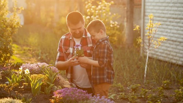 Dad and son spending free time together in garden. laughing and having fun