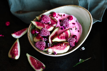 Healthy breakfast bowl  with yogurt, fresh figs and frozen berries