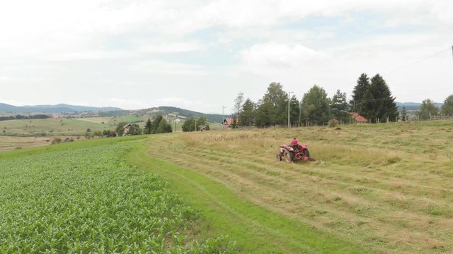 farmer cutting grass with tractor 