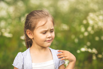 little girl is dissatisfied with something, on nature in summer
