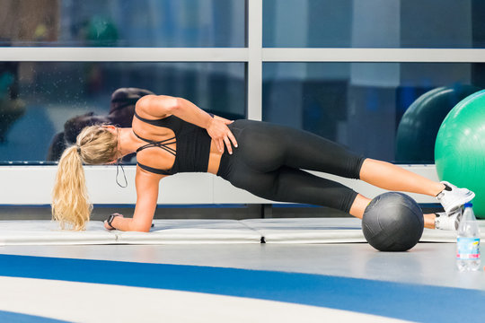 Attractive female athlete stretching with balls