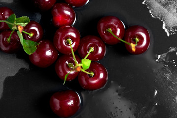 Ripe cherries on a dark background, top view.