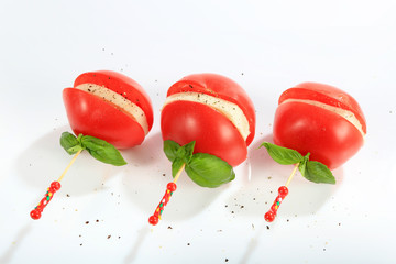 Mozzarella z pomidorem i bazylią nadziana na kolorową wykałaczkę posypana pieprzem. - obrazy, fototapety, plakaty