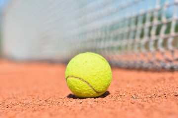 Tennis Ball on the Court with the Net in the background