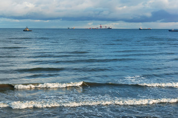 Oil and gas installations in the sea. Sea waves and clouds in the sky.