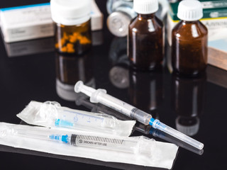 Medical Concept. Syringes, medical bottles with medications on a black background