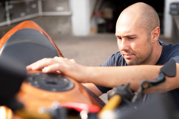 Mann putzt sein Motorrad