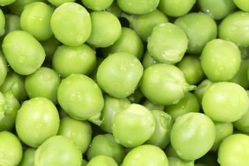 Green peas macro close up background. Horizontal photo of many peeled pea lying on the surface