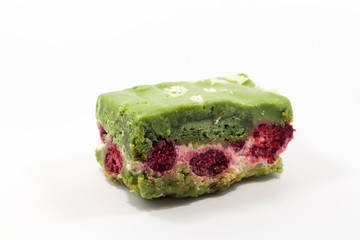 Delicsious fresh pistachio pastry sliced piece of cake with candied cranberries