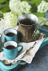 Cups of coffee and copper cerve on tray.