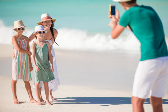 Family of four taking a selfie photo on their beach holidays.
