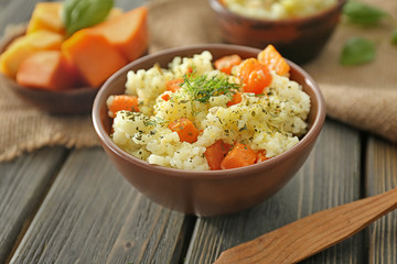 Bowl with delicious pumpkin risotto on wooden table