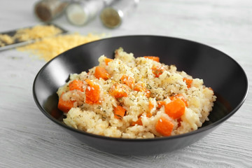 Bowl with delicious pumpkin risotto on wooden table