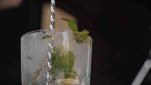 The barman makes a Mojito cocktail