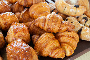 Assortment of delicious and buttery croissants made by pastry chef. All look very tasty and delightful. Natural light.