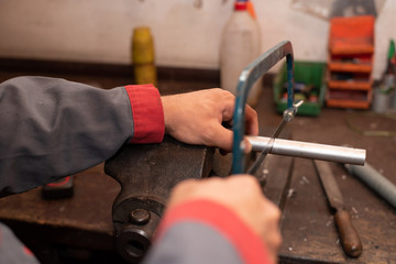 Mann sägt mit einer Säge in der Werkstatt