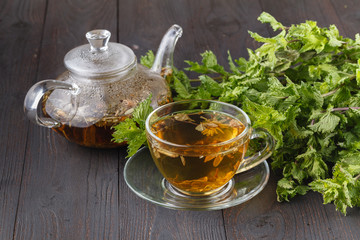 Cup of fresh herbal tea with mint on wooden table. Selective focus