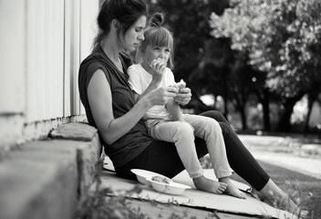 Poor people eating donated food on street, black and white effect