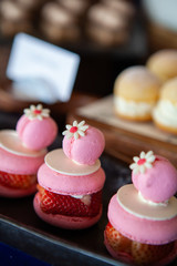 Cuteness overload, Delicious, mouthwatering and colorful Double Macarons filled with Fresh Summer Strawberry and cream, decorate with tiny flowers and white chocolate. Selective focus.