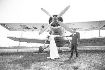 Newlyweds on a walk.Happy moments.Wedding photo shoot near the plane. Bride and groom, couple in love during a wedding photo session