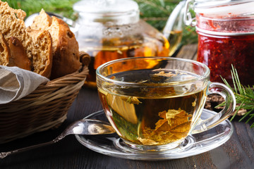 Cup of tea with berry jam on old wooden table