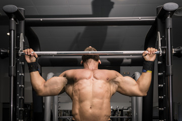 Hombre fuerte con grandes músculos haciendo dominadas en el gimnasio. Ponerse en forma.