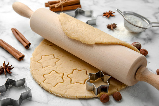 Rolling Pin And Raw Dough For Christmas Cookies On Light Table